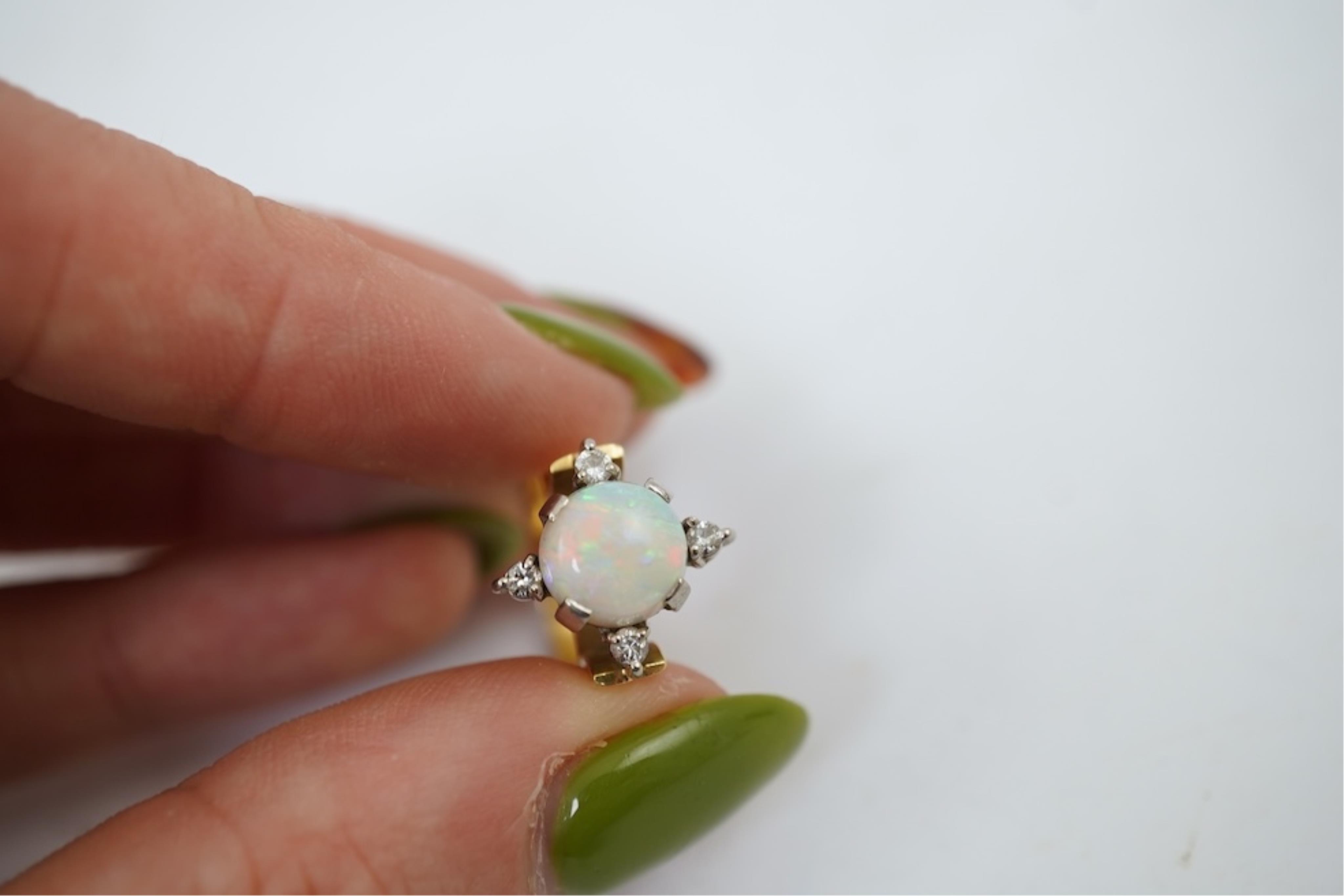 A yellow metal (stamped 18), single stone white opal and four stone diamond chip set ring, size P/Q, gross weight 3.8 grams.